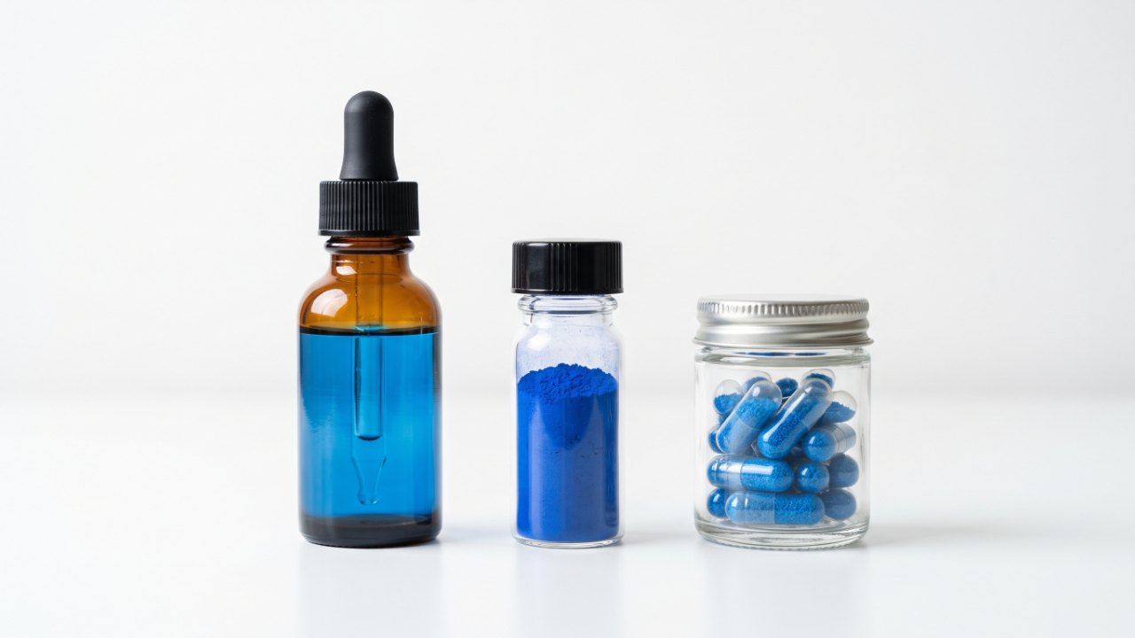 Three containers side by side on clean white surface, amber dropper bottle with blue liquid, small glass vial of blue powder, and clear capsules filled with blue content, studio lighting, soft shadows, product photography, no text, no labels, no watermark